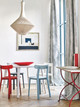 Coastal-inspired dining room with Peacock Dark Indigo drapery, white walls, layered blue tones, and accents of atomic red.